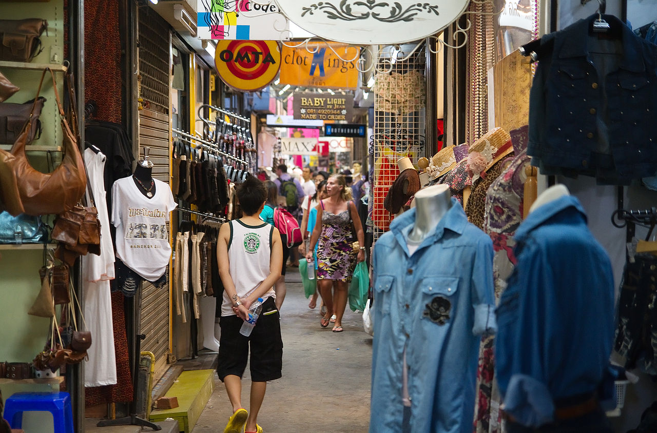 ซอยร้านเสื้อผ้าวินเทจในตลาดนัดจตุจักร — เสื้อผ้ามือสอง กระเป๋าหนัง และคนเดินเลือกซื้อของ