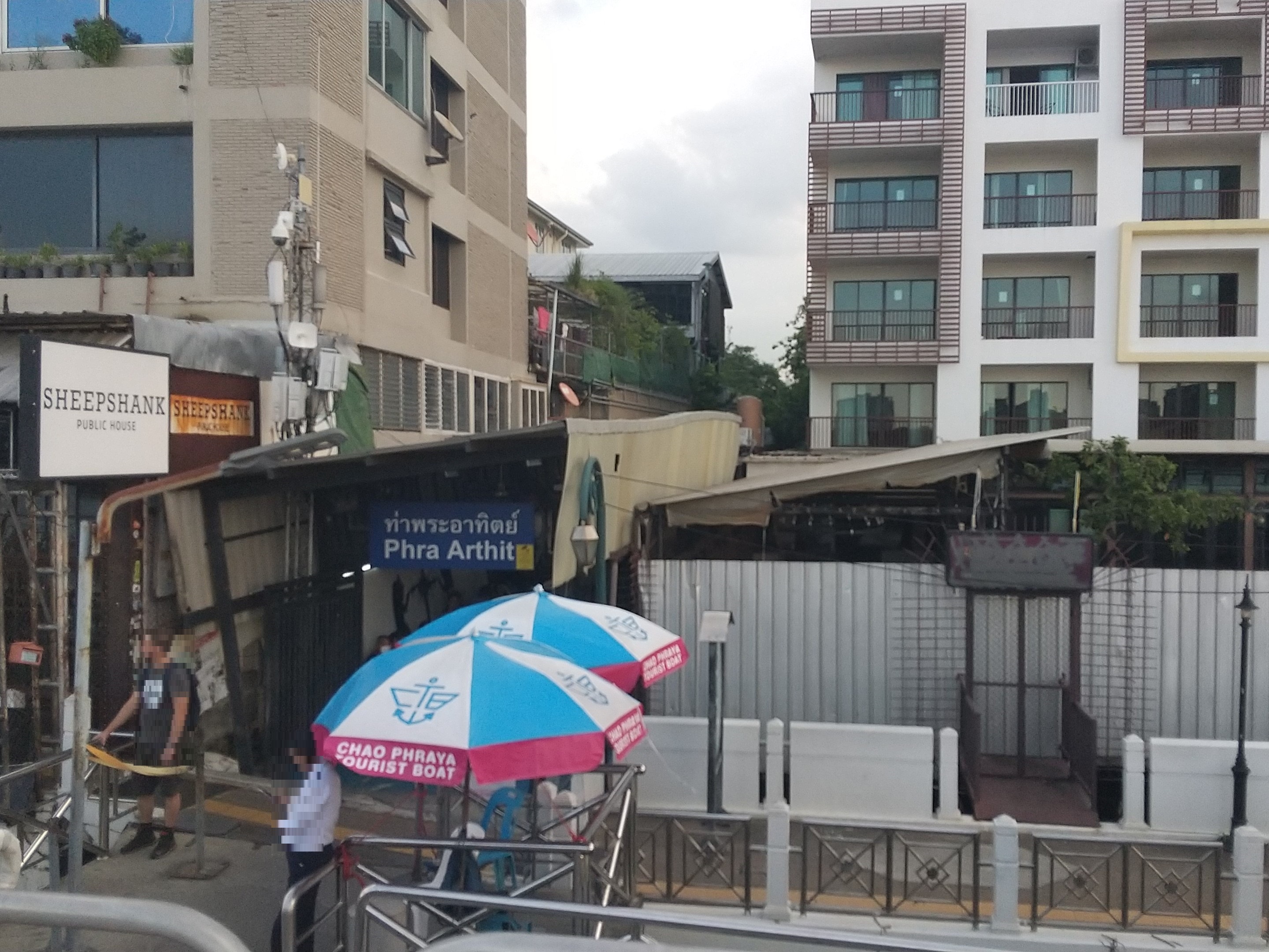 The entrance to Phra Athit pier on the Chao Phraya River, with Chao Phraya Tourist Boat umbrellas, near Khao San Road in Bangkok
