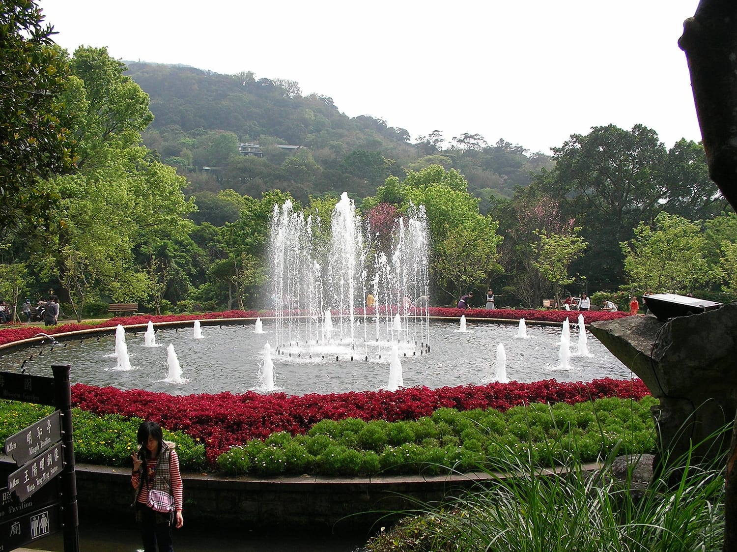 นาฬิกาดอกไม้และน้ำพุที่สวนหยางหมิงในอุทยานหยางหมิงซาน แปลงดอกไม้สีแดงล้อมรอบสระน้ำพุ