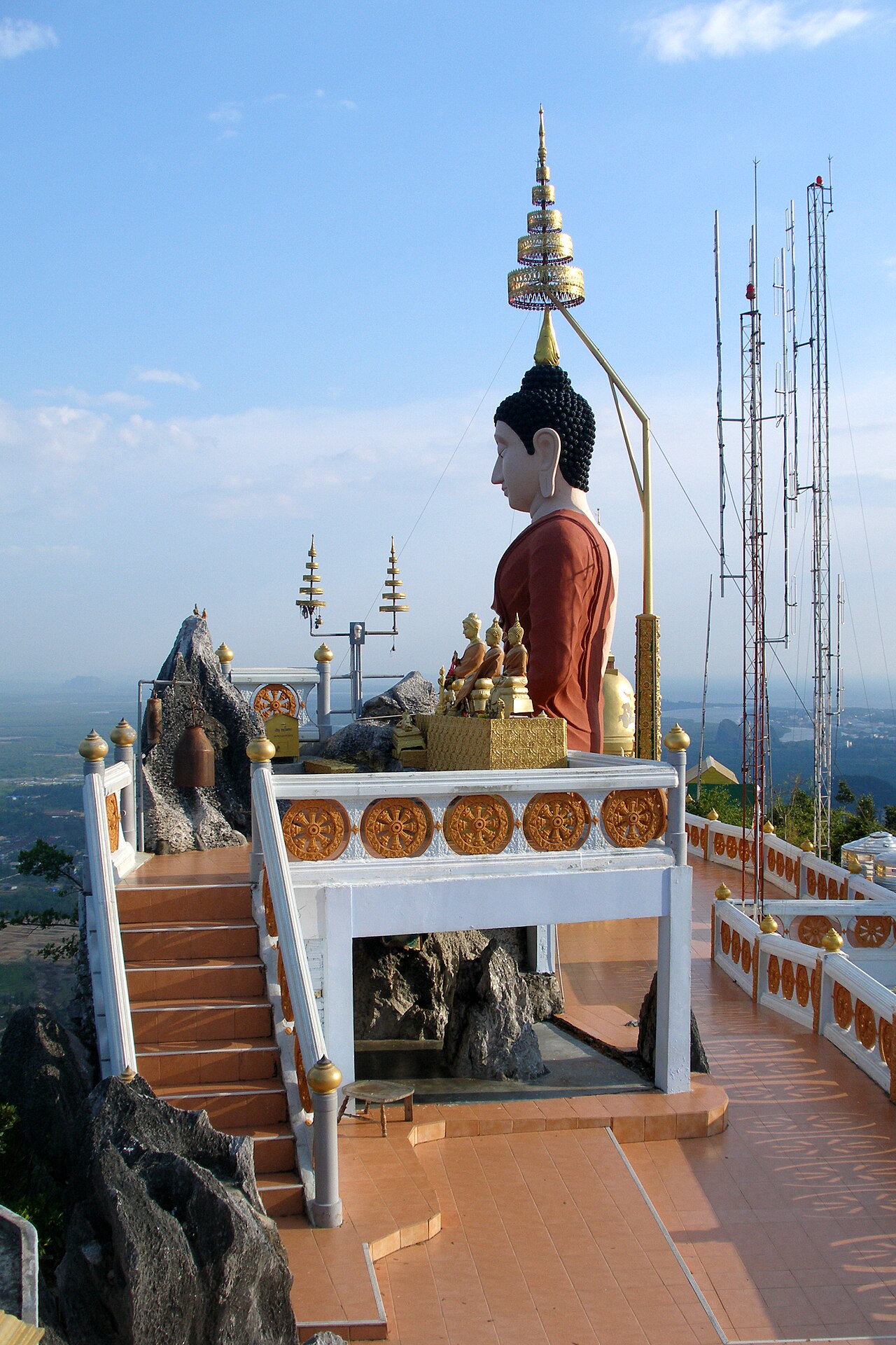 ลานยอดเขาวัดถ้ำเสือ กระบี่ มีพระพุทธรูปและเจดีย์ มองเห็นวิวที่ราบเบื้องล่าง