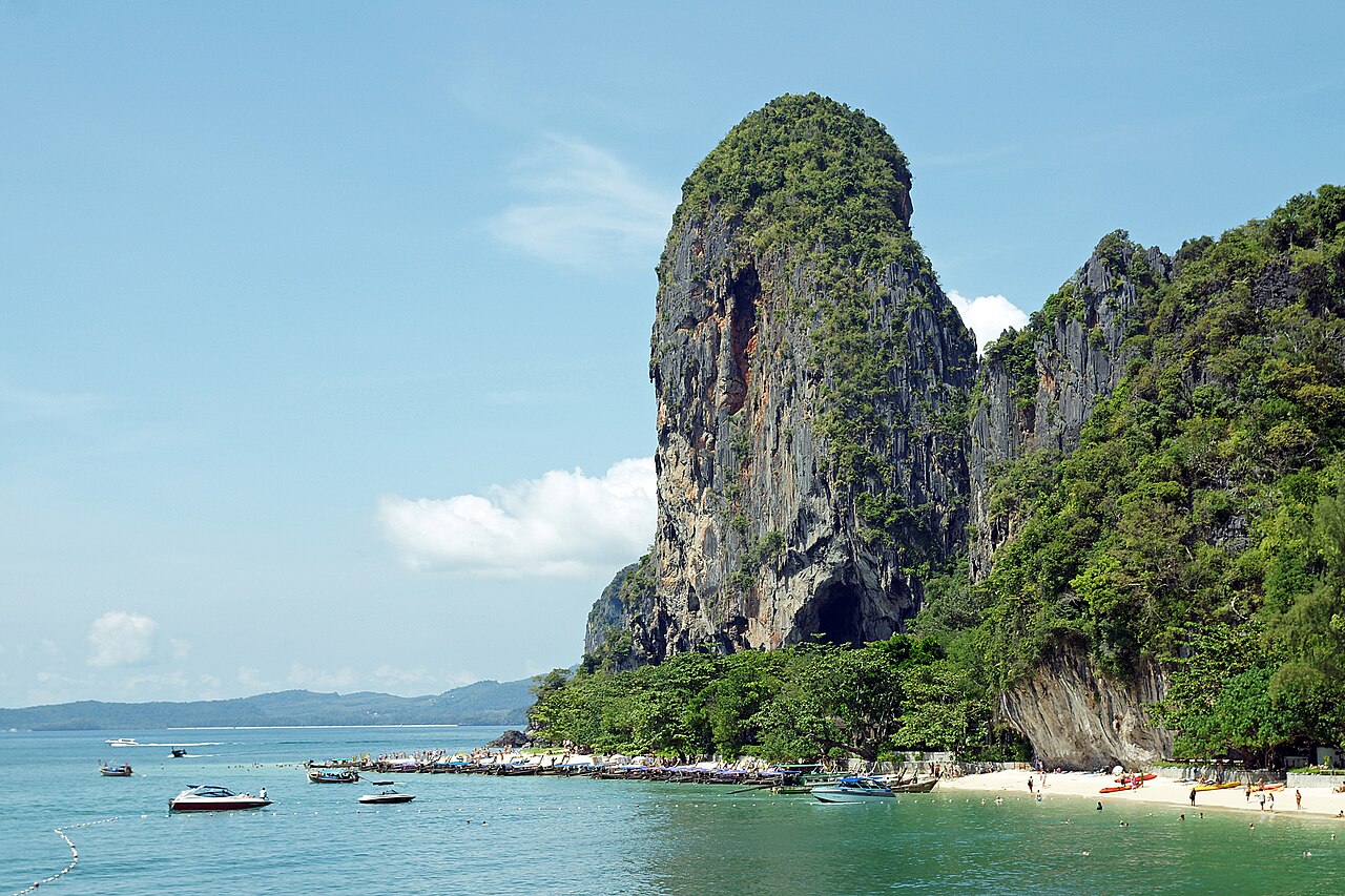 หาดพระนาง ไร่เลย์ กระบี่ — หาดทรายขาวน้ำมรกตกับหน้าผาหินปูนสูงตระหง่านและเรือหางยาวจอดริมหาด