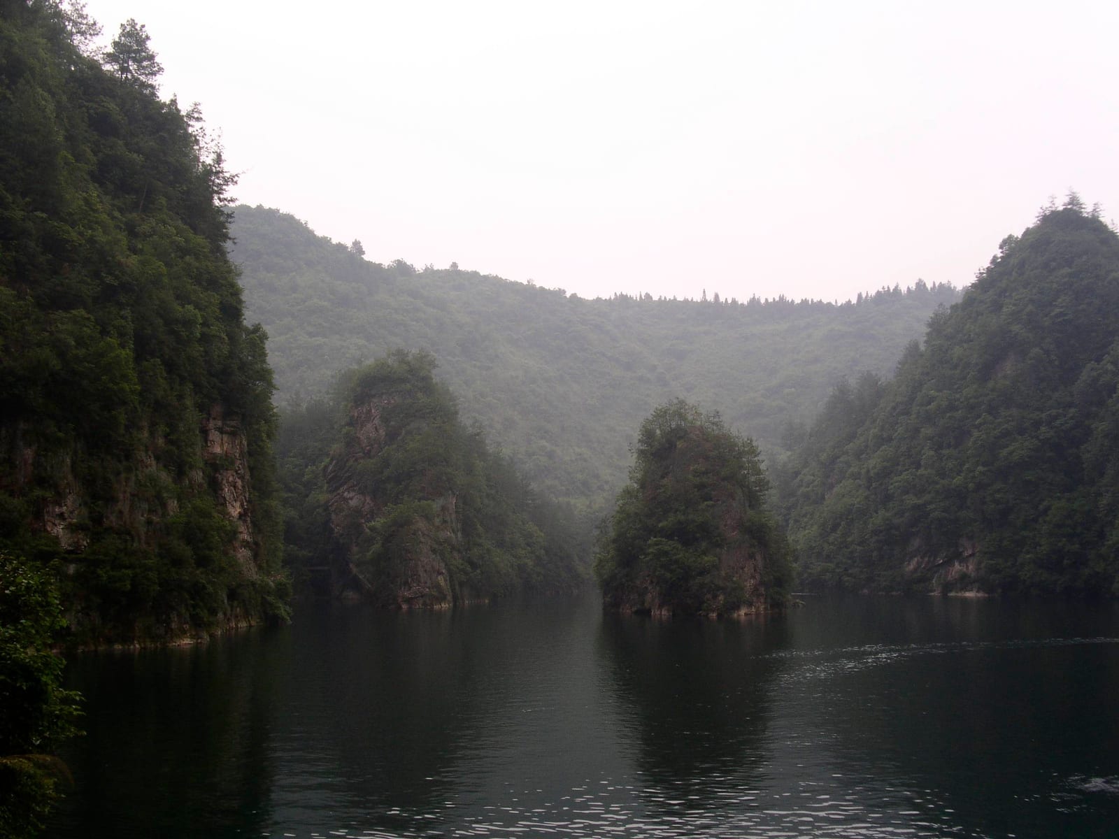 ทะเลสาบเป่าเฟิง จางเจียเจี้ย — ทะเลสาบบนเขาสีเขียวล้อมด้วยยอดเสาหิน เรือล่องผ่านผืนน้ำนิ่ง