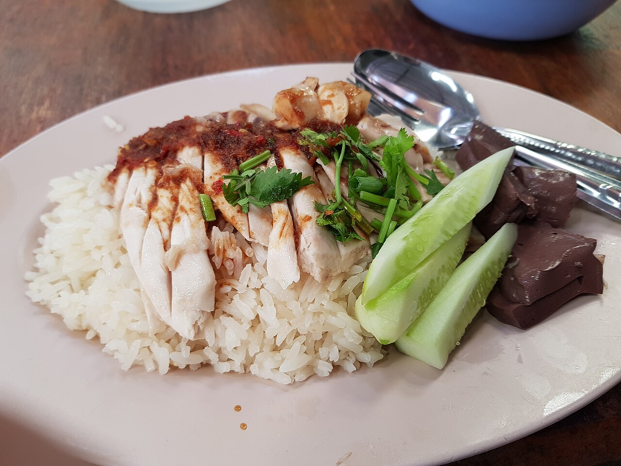 ข้าวมันไก่ — ไก่ต้มหั่นเรียงบนข้าวมัน เสิร์ฟพร้อมน้ำจิ้มเต้าเจี้ยวและน้ำซุป