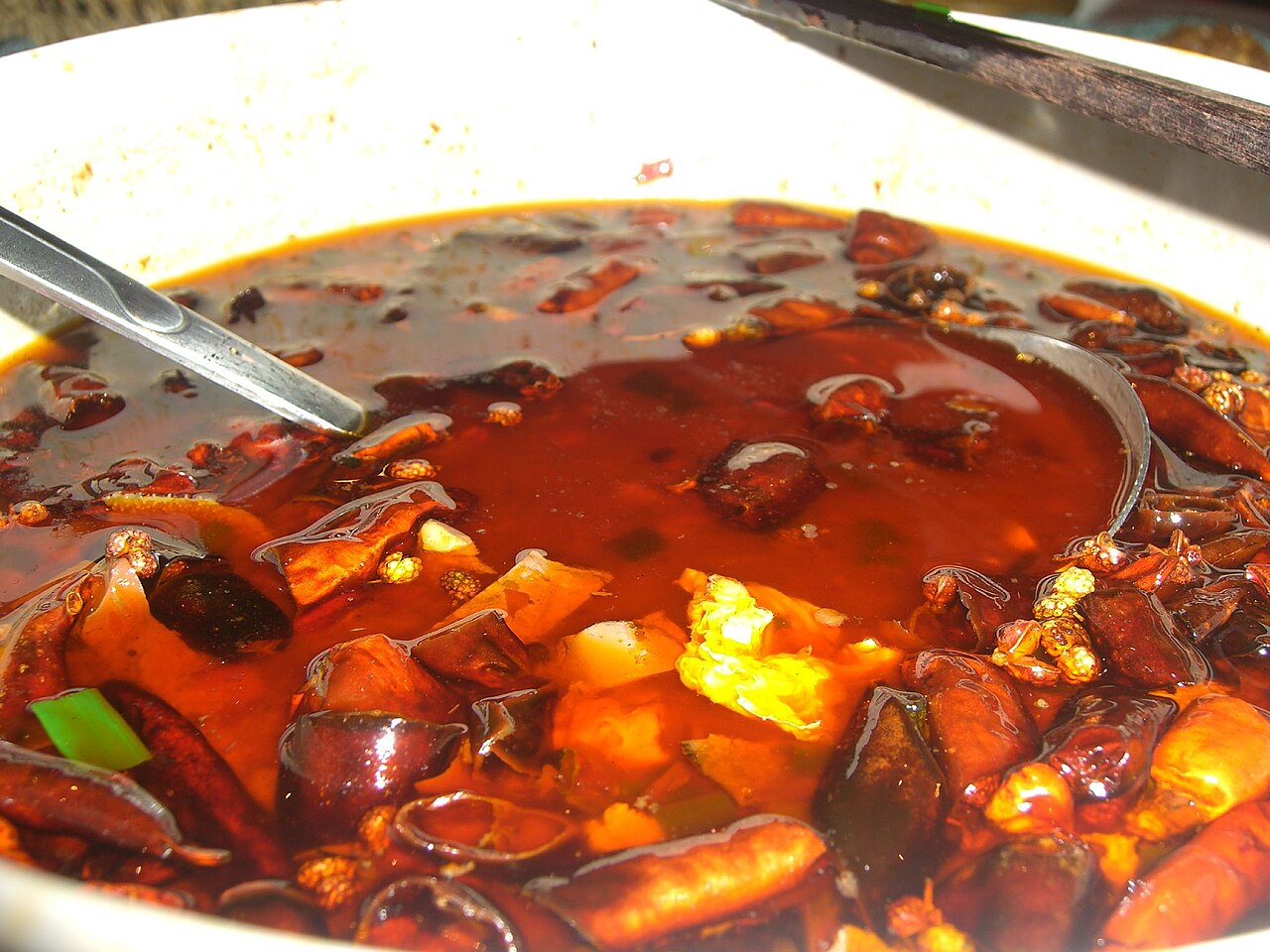เหมาเสวี่ยวั่ง หม้อต้มน้ำซุปพริกสีแดงเข้มเดือดพล่าน มีเลือดเป็ด เครื่องในและพริกแห้งลอยอยู่บนผิวน้ำมัน