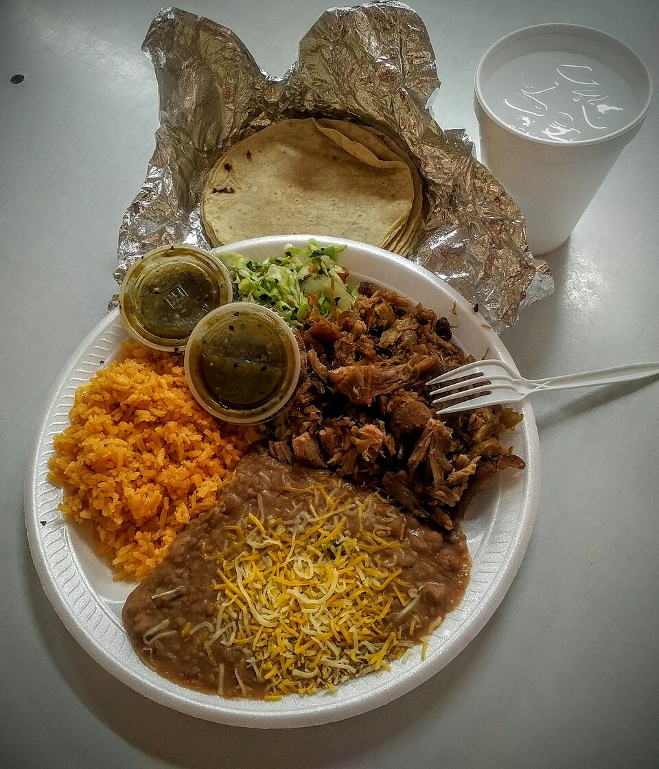 Carnitas braised shredded pork plated with tortillas