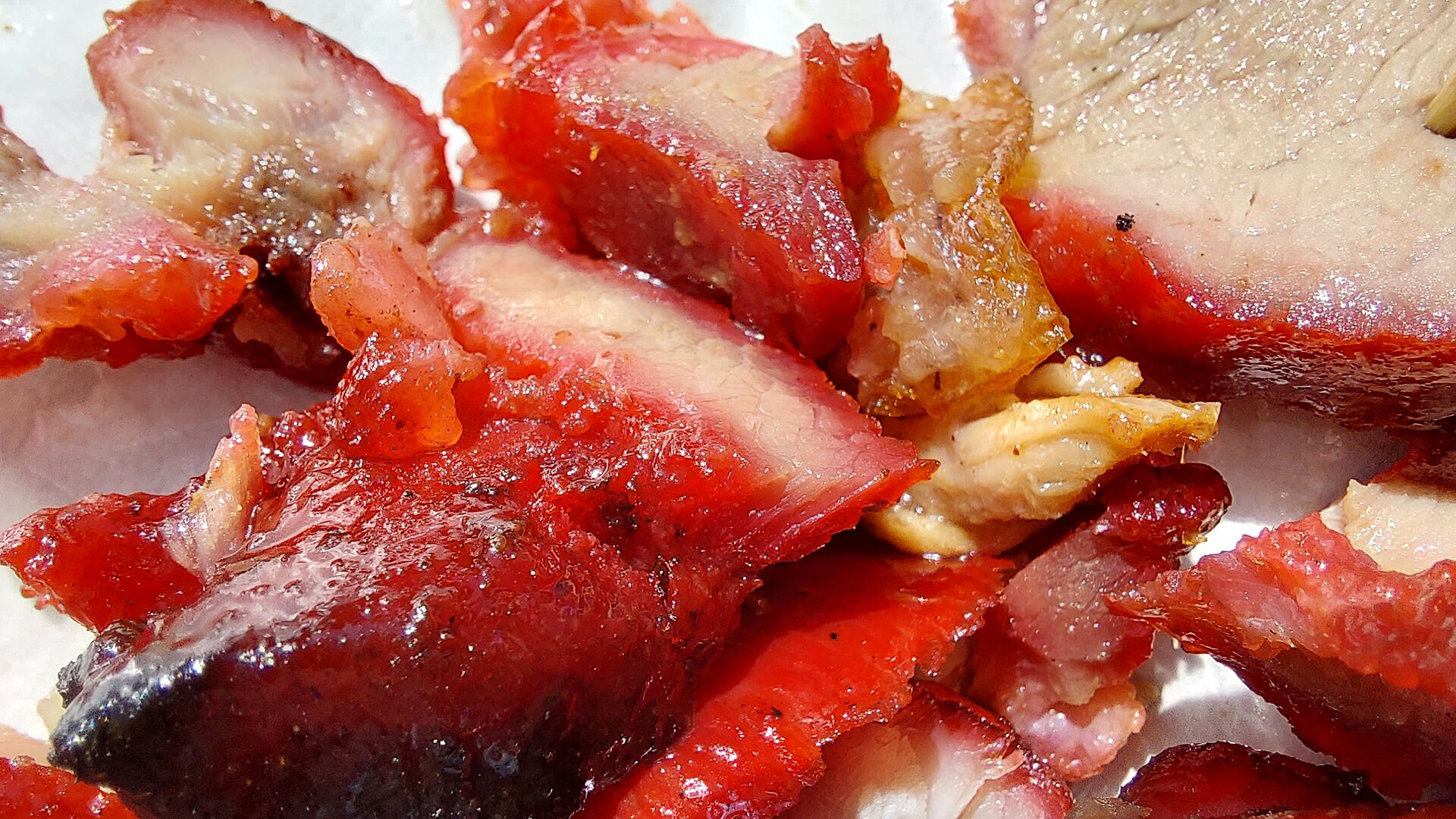 หมูแดงฉาซิว (char siu) กว่างโจว — หมูย่างเคลือบน้ำผึ้งสีแดงเงาวาว หั่นชิ้นวางบนจาน