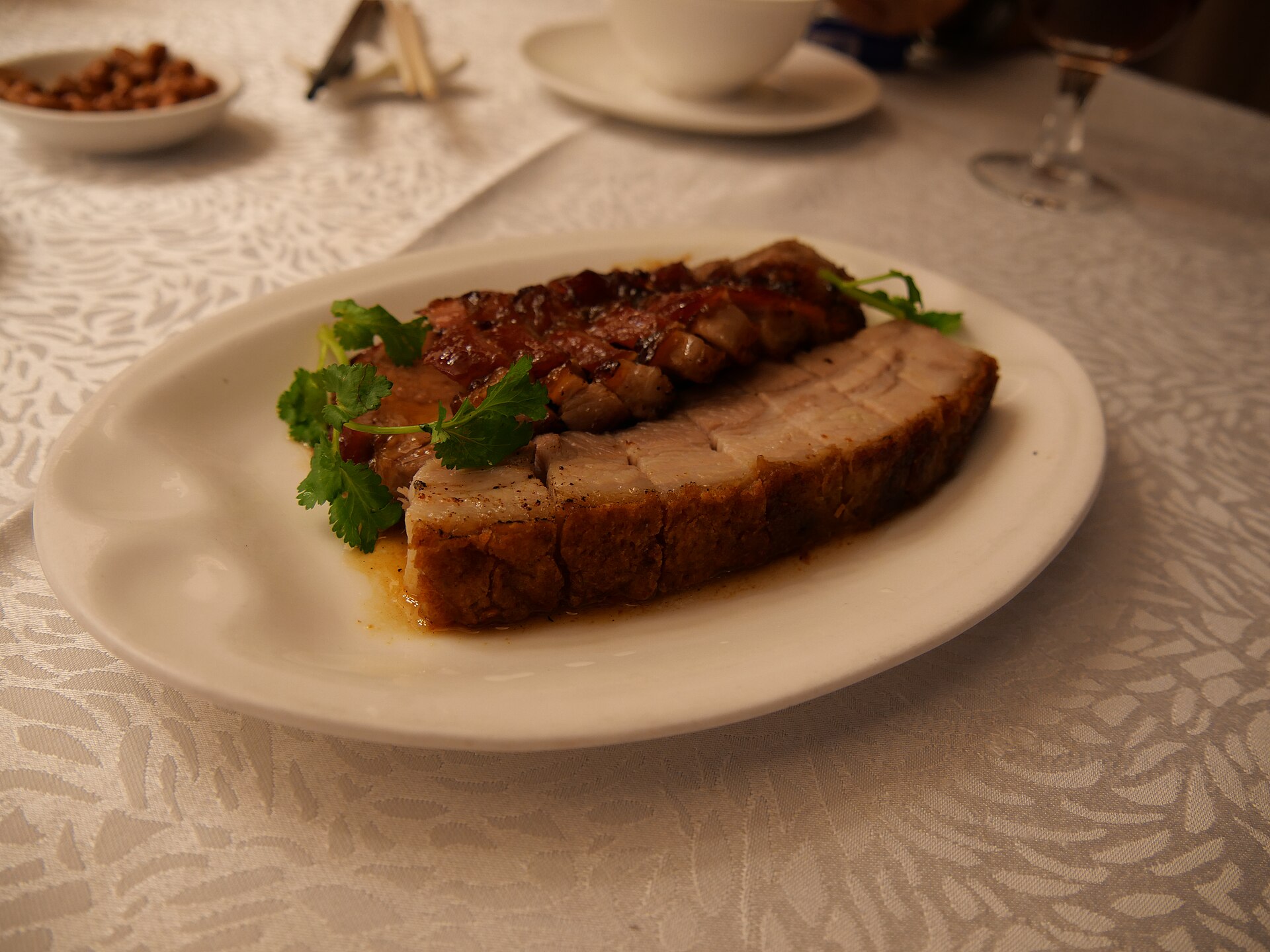 เซียวโร่ว หมูสามชั้นย่างกวางตุ้ง หนังกรอบฟูเป็นเกล็ดสีทอง วางคู่หมูแดงบนจานขาว