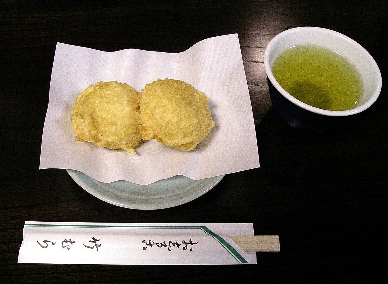 มันจู (manju) สองชิ้นบนจานเซรามิกสีเขียวอ่อนพร้อมชาเขียว — ขนมหวานดั้งเดิมญี่ปุ่นที่ขายในเมืองออนเซ็นอย่างฮาโกเน่