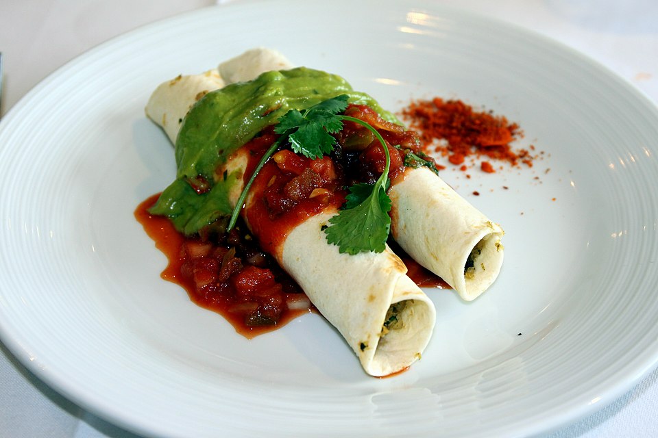 enchiladas Tex-Mex ราดซอสและชีสในจาน