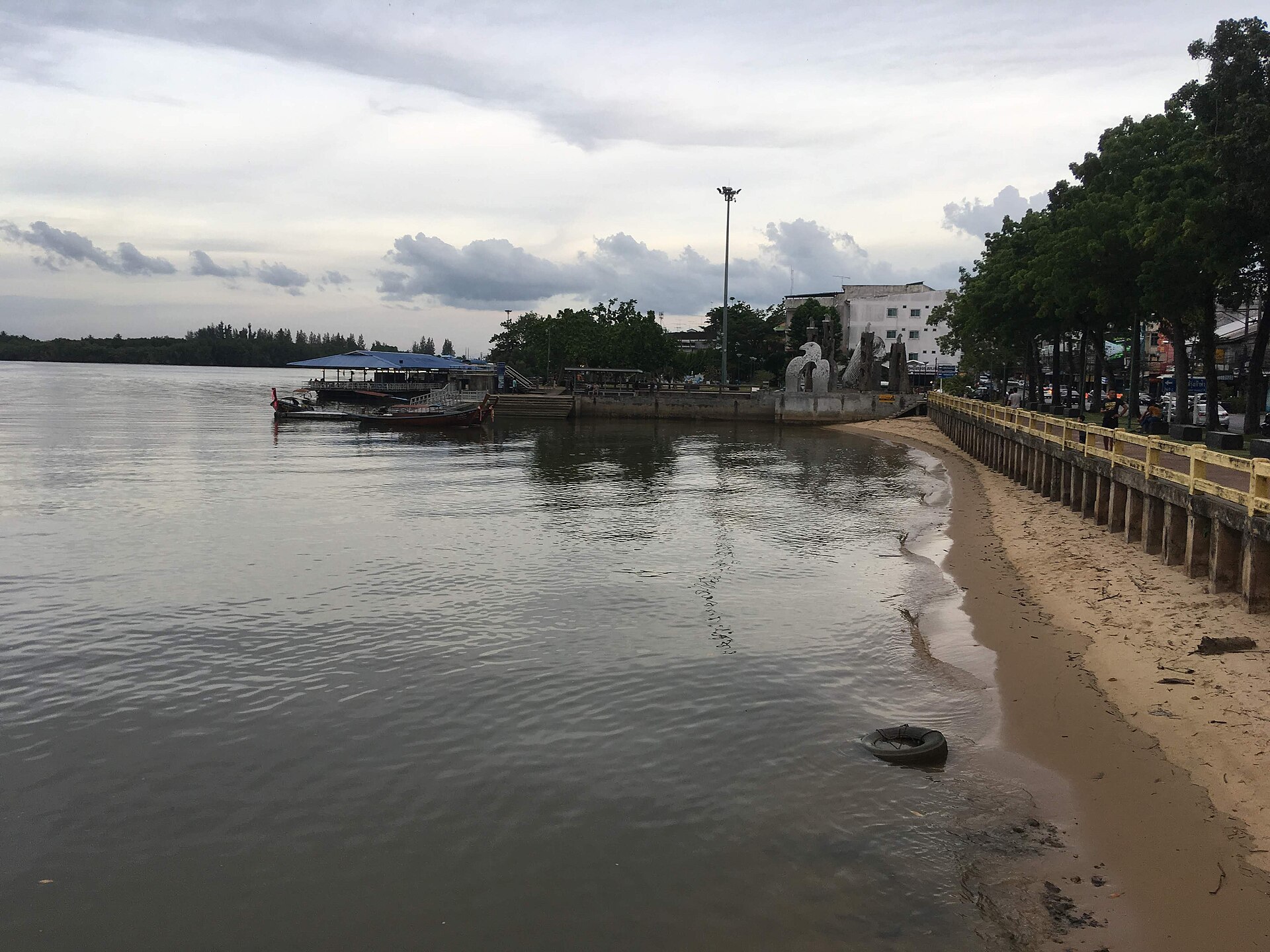 ริมแม่น้ำกระบี่ในตัวเมือง กับเรือหางยาวและทางเดินเลียบน้ำ — ย่านร้านซีฟู้ดราคาเป็นมิตรของคนท้องถิ่น