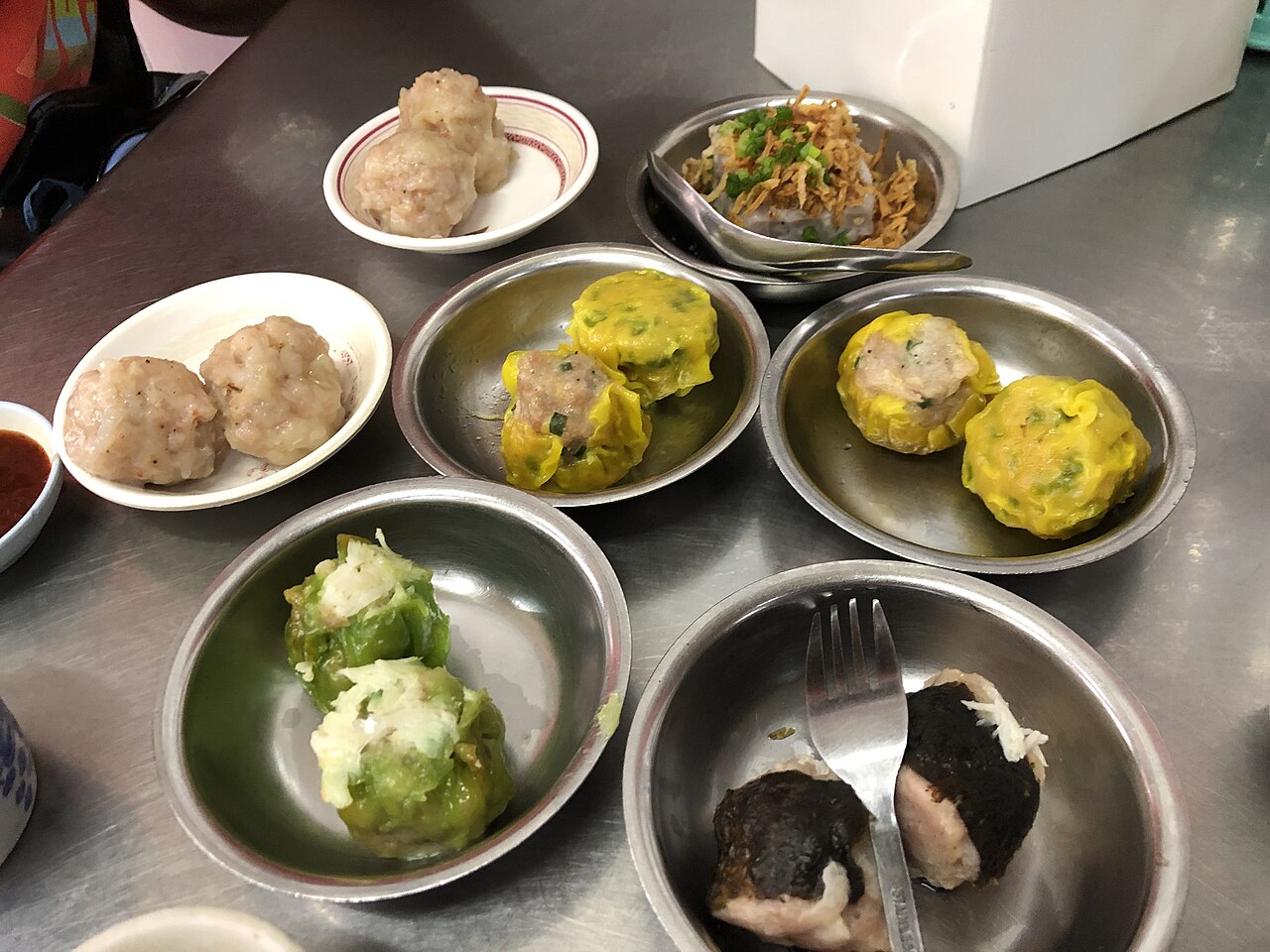 ติ่มซำภูเก็ตหลายอย่างในถ้วยเล็ก ขนมจีบ ฮะเก๋า ขนมจีบกุ้ง วางเรียงบนโต๊ะ มื้อเช้าของคนภูเก็ต