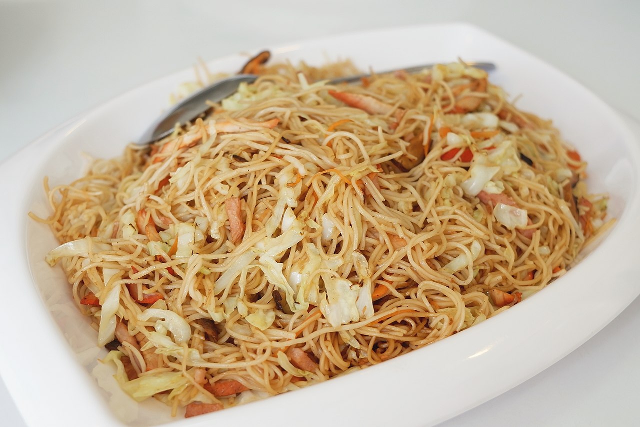 หมี่ฮกเกี้ยนภูเก็ต เส้นหมี่เหลืองผัดน้ำข้นกับกุ้ง หมู ผักกะหล่ำ จัดเรียงในจานสีขาว