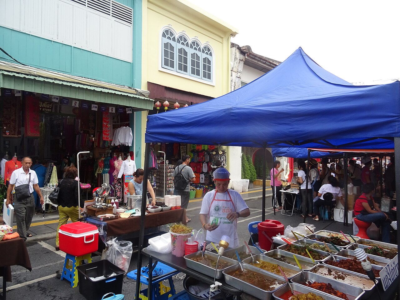 ตลาดนัดริมถนนถลางในเมืองเก่าภูเก็ต มีแผงขายกับข้าวและของสดท่ามกลางตึกชิโน-โปรตุกีส ตัวอย่างบรรยากาศการเดินตลาดที่หลายคลาสเรียนทำอาหารพาไปก่อนเริ่มทำอาหาร