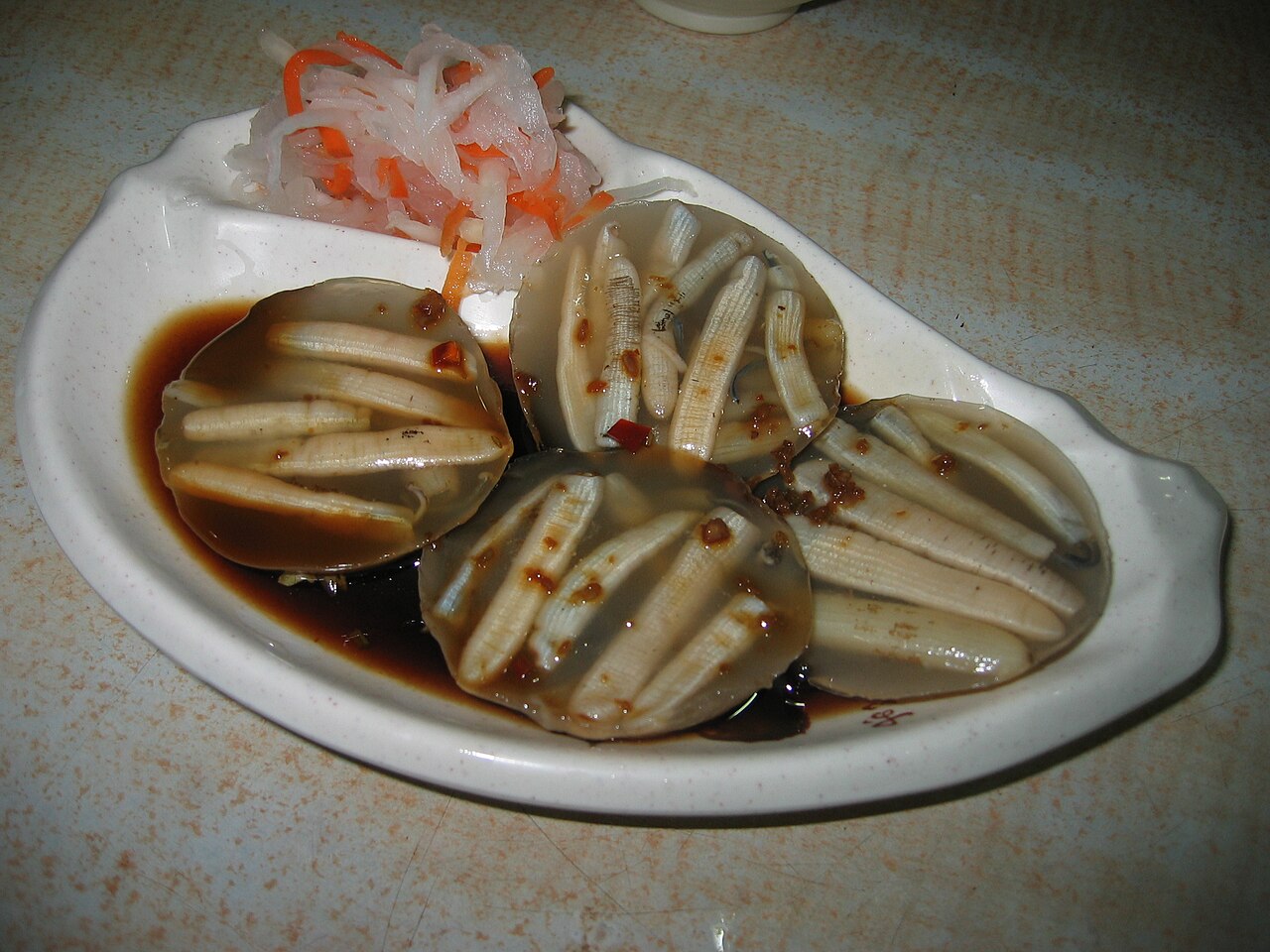 土笋冻 วุ้นหนอนทะเล จัดเป็นแผ่นวุ้นใสมีตัวหนอนฝังอยู่ข้างใน วางในซอสซีอิ๊วพร้อมหัวไชเท้าดอง