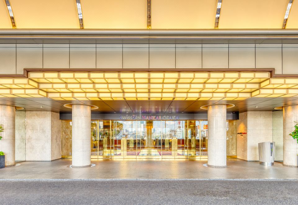 ทางเข้าโรงแรม Swissôtel Nankai Osaka พร้อมป้ายชื่อเหนือพอร์ทโคเชร์