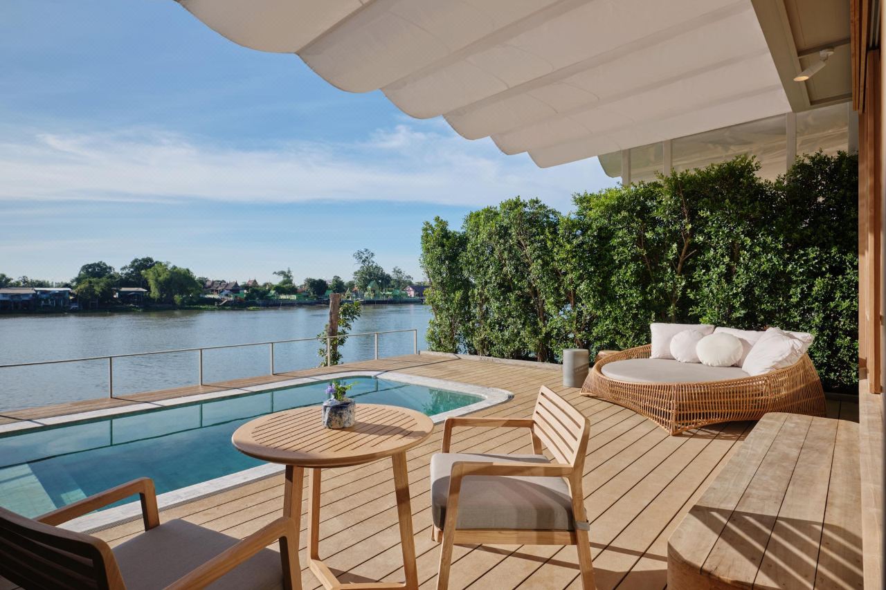 Pool villa terrace with a private plunge pool and daybed overlooking the river