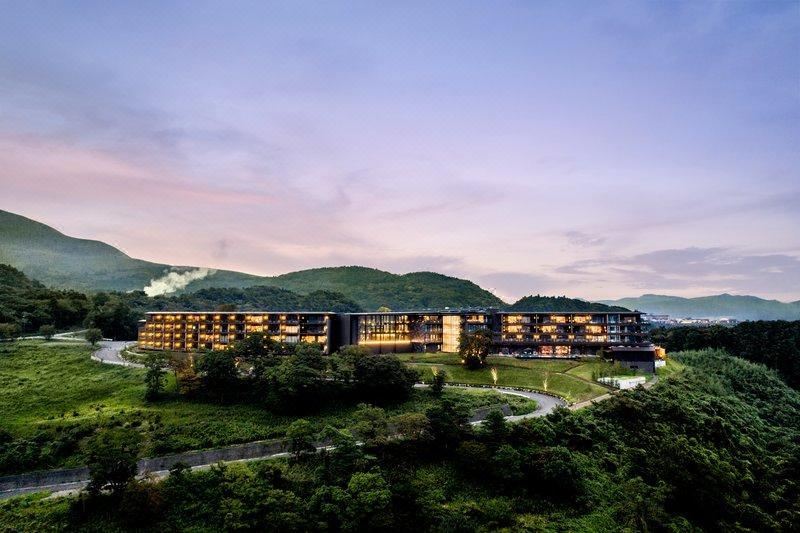 ANA InterContinental Beppu ตัวอาคารหลักบนเนินเขา มองจากด้านหลังเห็นสันเขาและหมอกควันบ่อน้ำร้อน