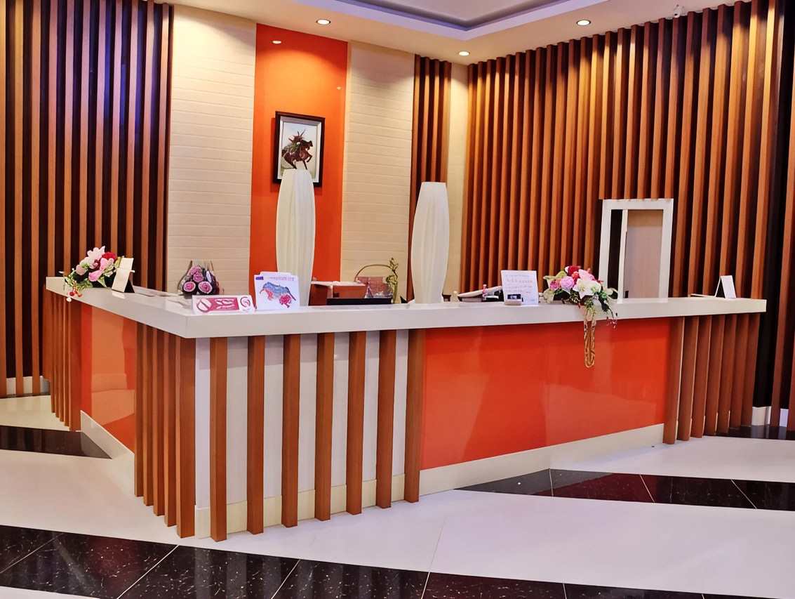 ล็อบบี้และเคาน์เตอร์ต้อนรับโทนส้ม-ไม้ของ BK Place Hotel