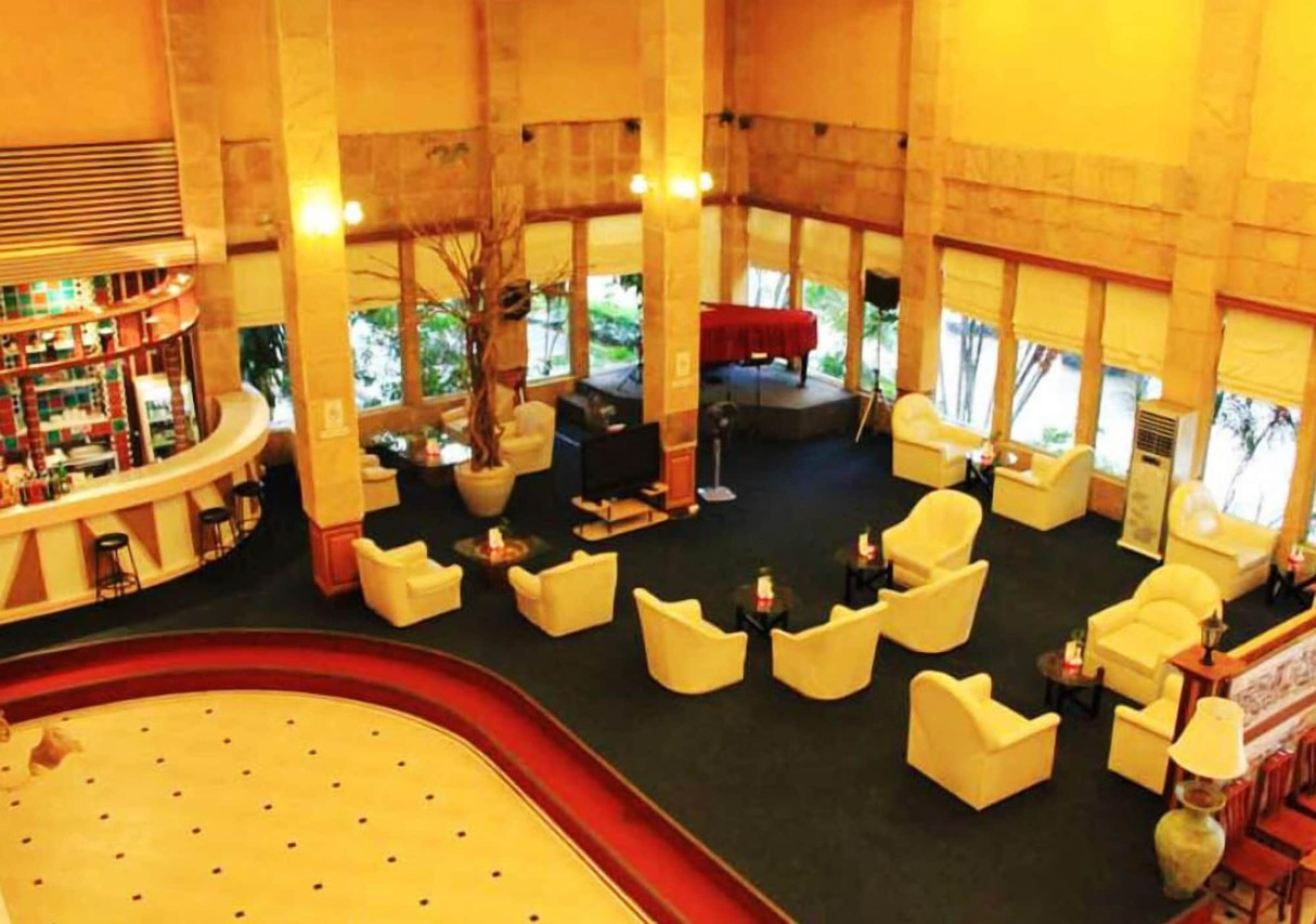 ล็อบบี้เสาหินสูงโปร่งพร้อมเก้าอี้นวมและเปียโนของ Thepnakorn Hotel