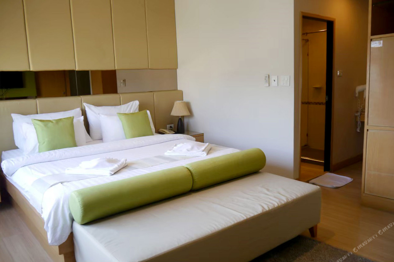 ห้องพักของ Lertnimit Hotel ชัยภูมิ ตกแต่งโทนอบอุ่นมีหมอนเขียว