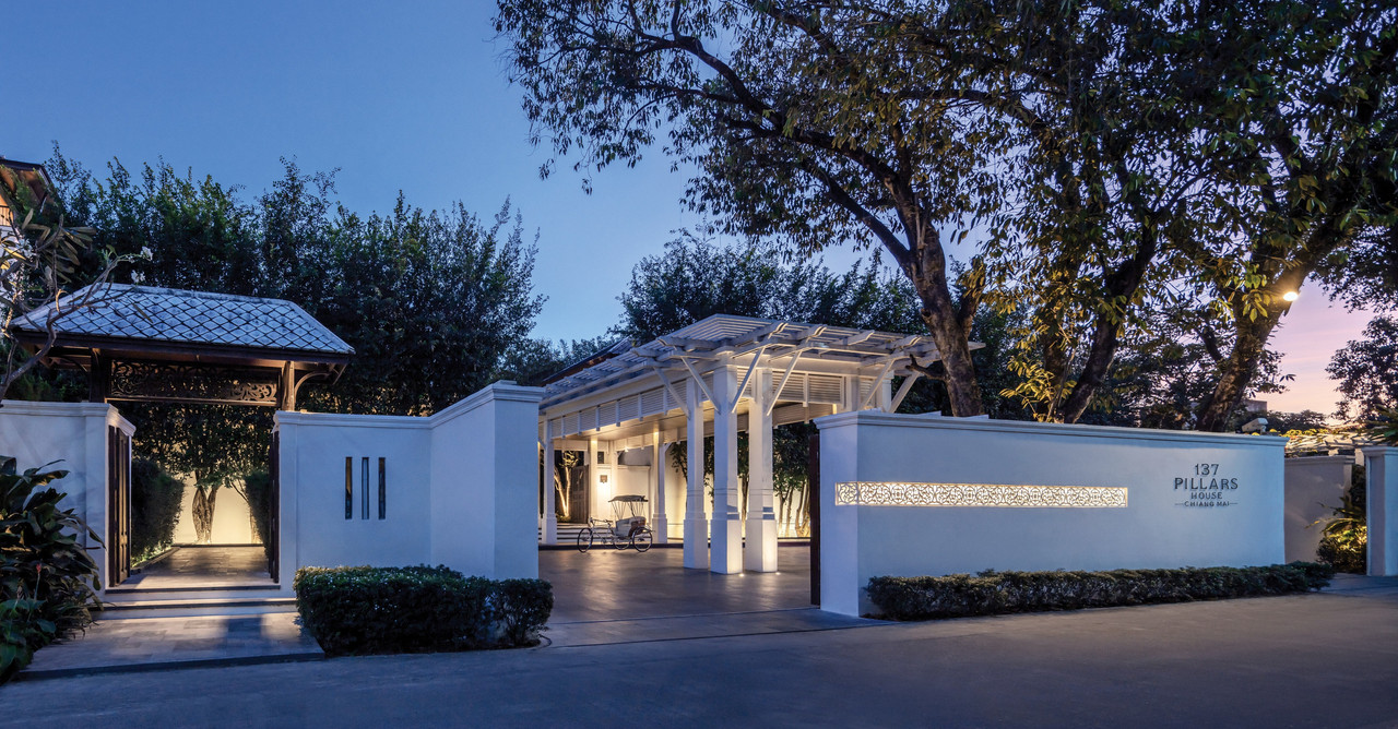 ประตูทางเข้า 137 Pillars House ยามพลบค่ำ ป้ายโรงแรมสว่างไสว