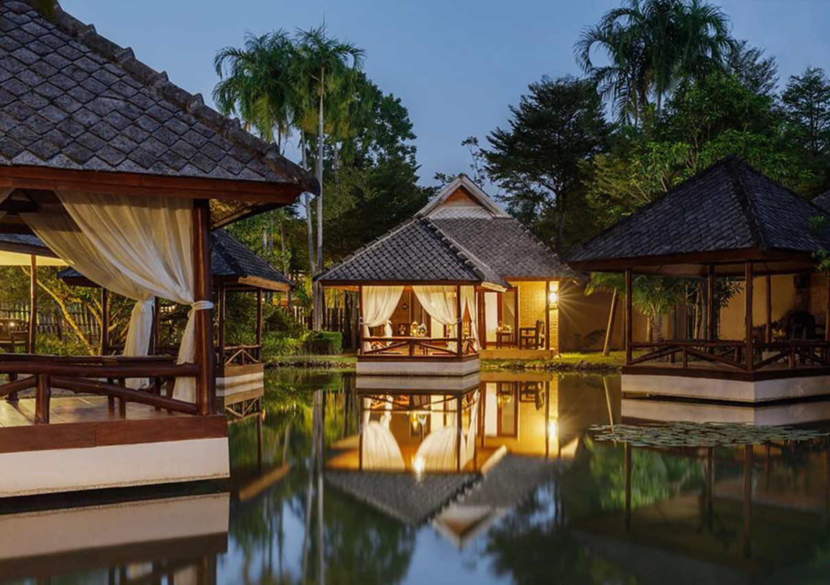 ศาลาไม้สไตล์ Lanna สะท้อนเงาในบ่อน้ำยามเย็นที่ Phowadol Resort เชียงราย