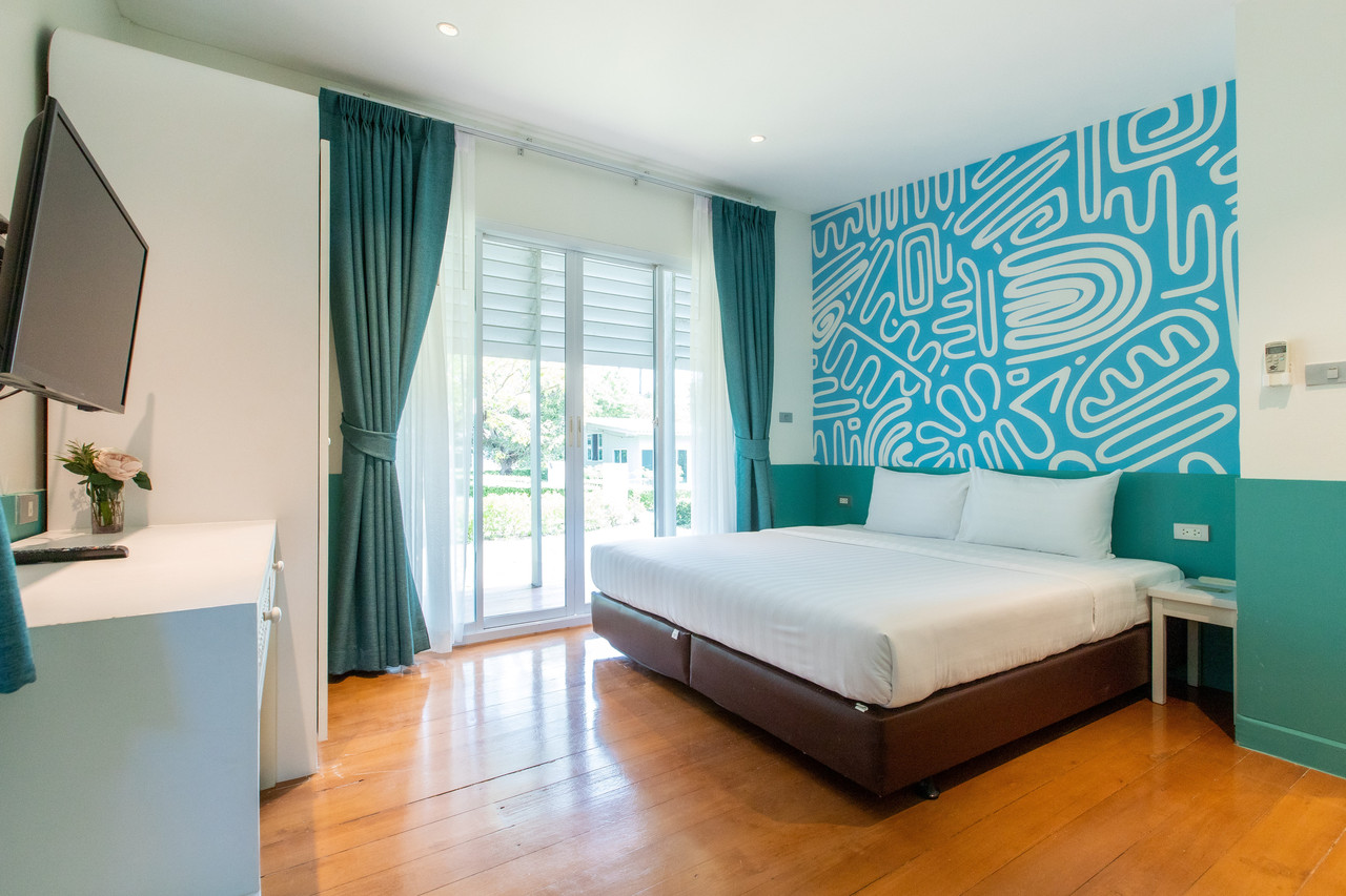 ห้องพักโทนสีเขียวมิ้นต์ มีระเบียงมองเห็นสวน Bangsaen Heritage Hotel