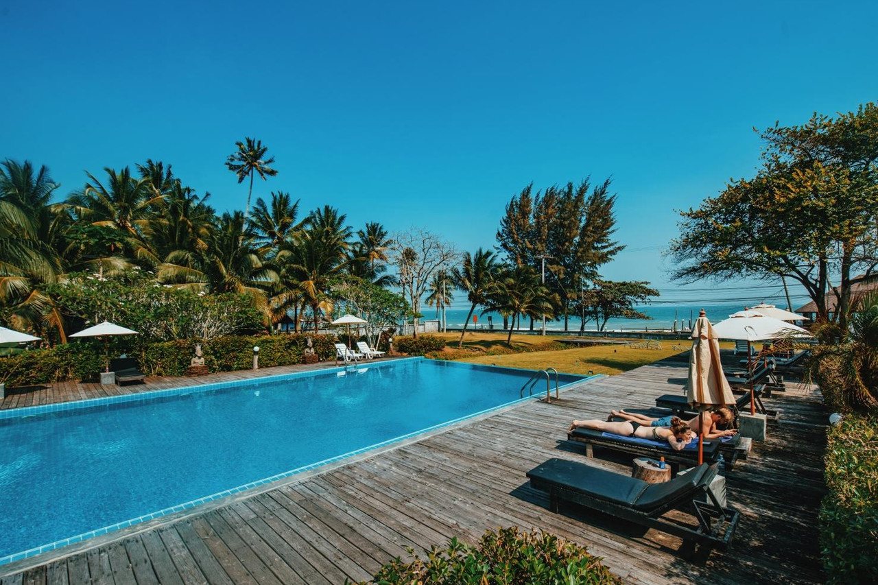สระว่ายน้ำกลางแจ้งของ Nana Beach Resort มองเห็นทะเลและทิวสน