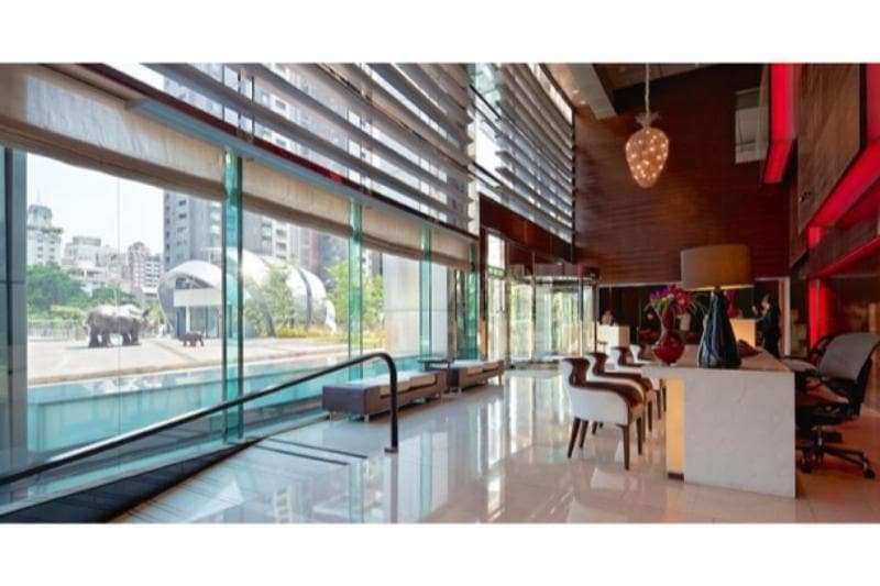 ล็อบบี้หรูสไตล์โมเดิร์นของ Hotel ONE Taichung พร้อมกระจกบานใหญ่มองเห็นสวน Caowu Trail