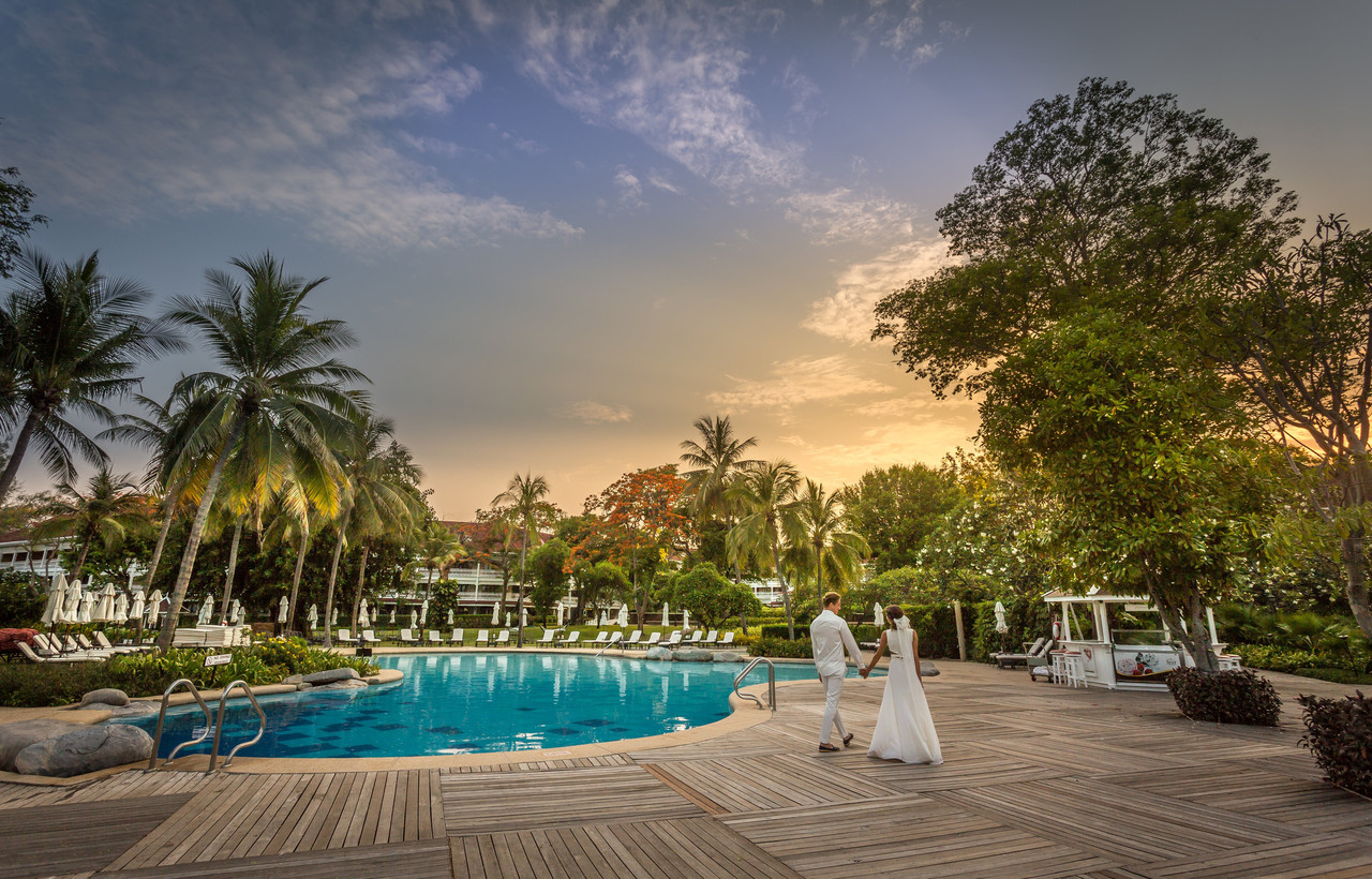 สระว่ายน้ำยามเย็นกับอาคารโคโลเนียลและสวน topiary ที่ Centara Grand Hua Hin
