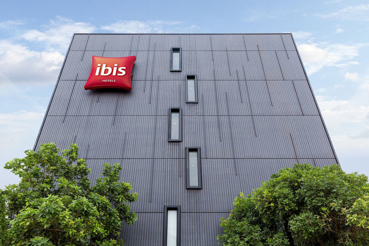 ป้ายโลโก้ ibis สีแดงบนผนังอาคาร ibis Hua Hin