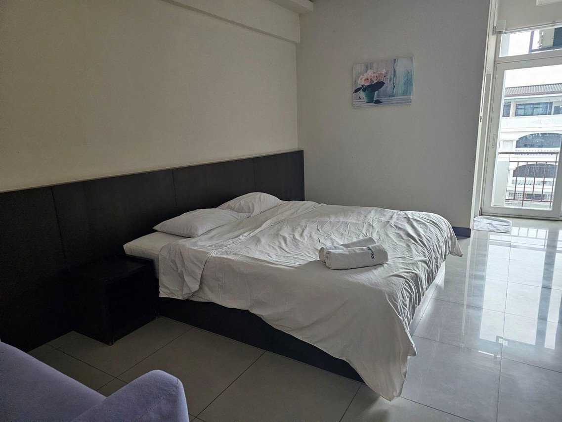 ห้องพักเตียงใหญ่ของ Phaiboon Place Hotel พื้นกระเบื้องสะอาด มีประตูออกระเบียง