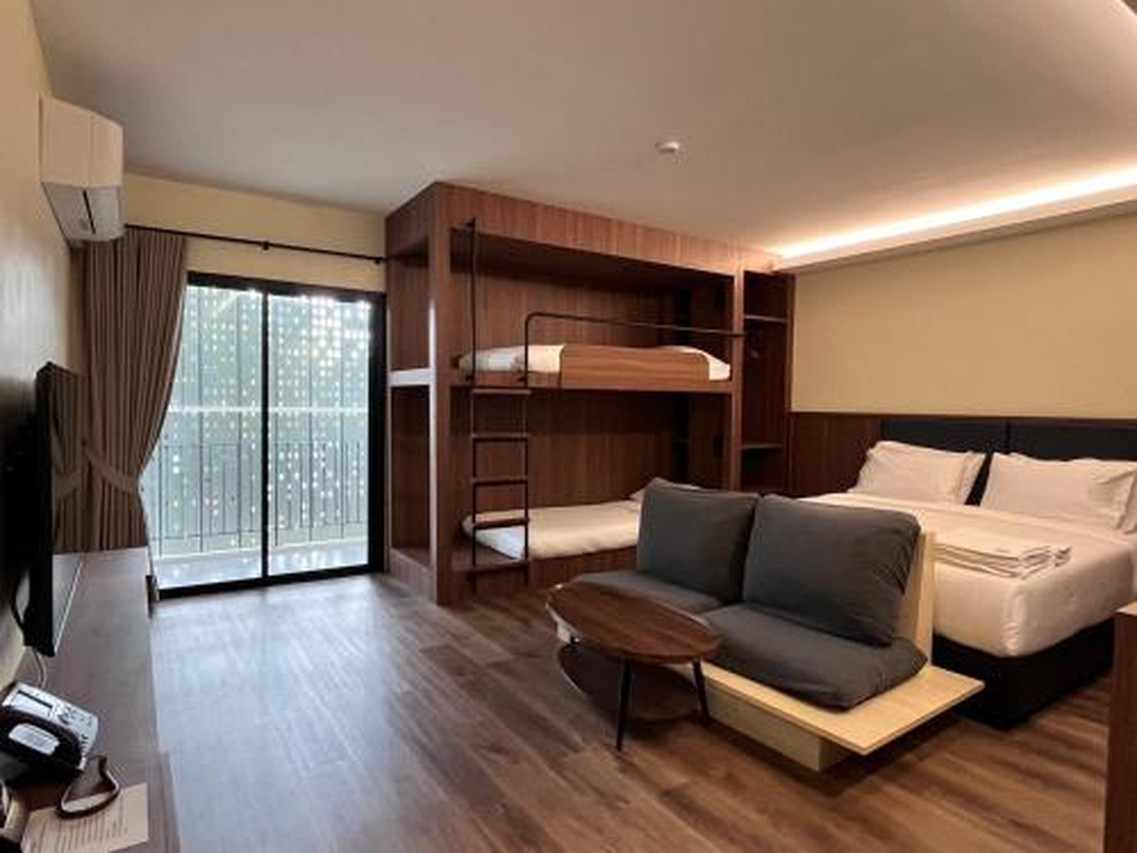 ห้อง Family Suite ของ J2 Hotel มีเตียงคิง เตียงสองชั้น โซฟา และระเบียง