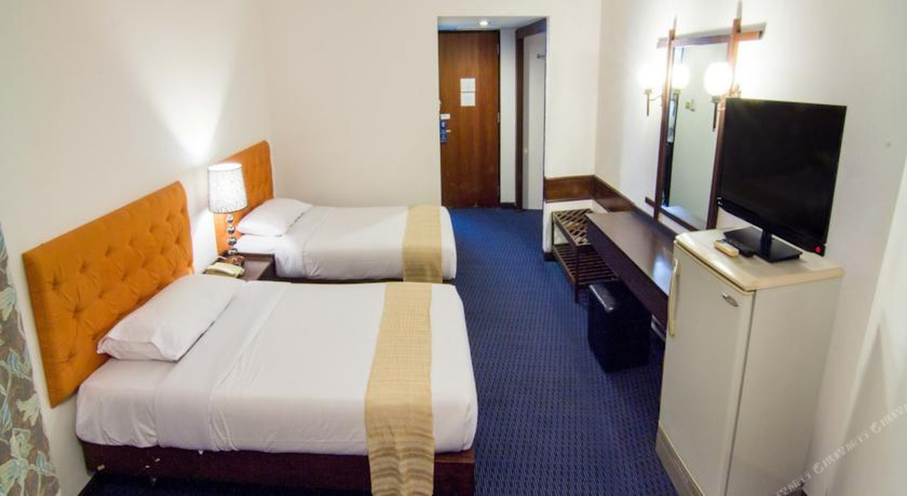 ห้องพักเตียงคู่ของ Phet Hotel กำแพงเพชร พื้นพรมน้ำเงิน หัวเตียงสีส้ม