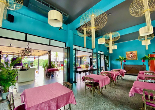 Peace Space restaurant with turquoise walls, pink table linens and bamboo lantern lighting
