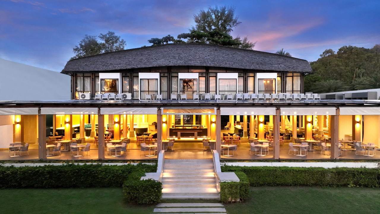 Round two-storey Bua Fah Restaurant building open to the gardens, lit up at dusk at Twin Lotus Resort Koh Lanta