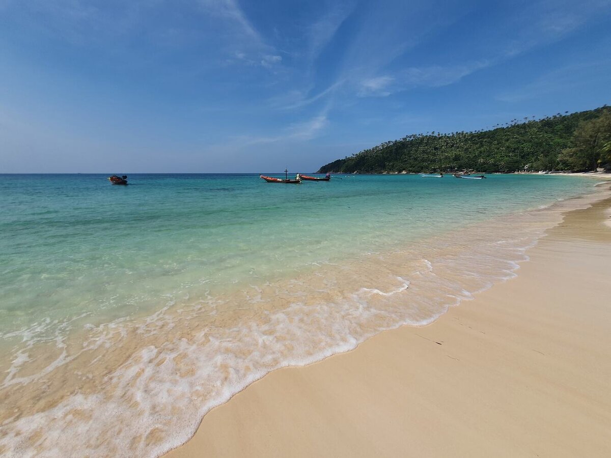 Haad Salad beach at Salad Hut with clear turquoise water and longtail boats, Koh Phangan
