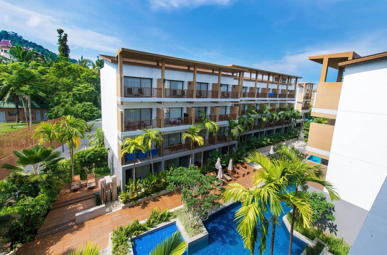 อาคารรีสอร์ทแบบ low-rise มีระเบียงทุกห้องและสระด้านหน้า