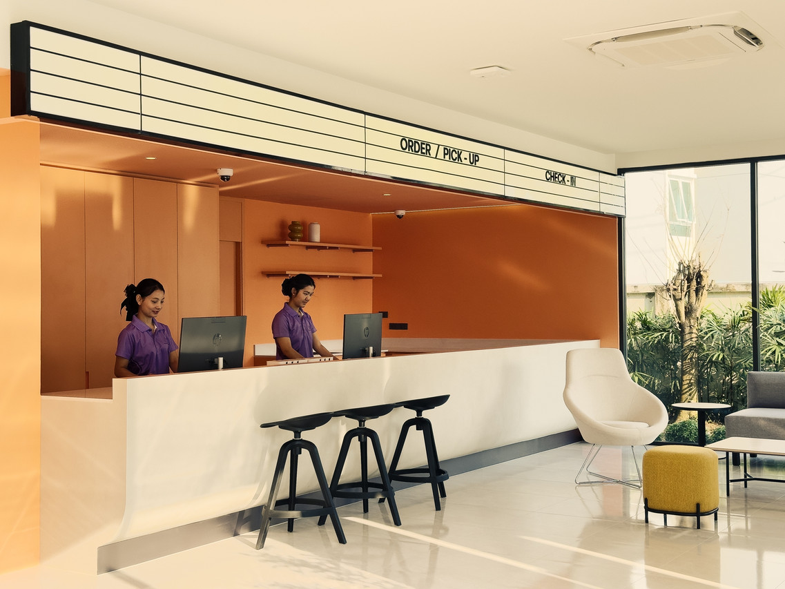 เคาน์เตอร์ต้อนรับโทนสีส้มสไตล์โมเดิร์นของ Fortune D Hotel Loei
