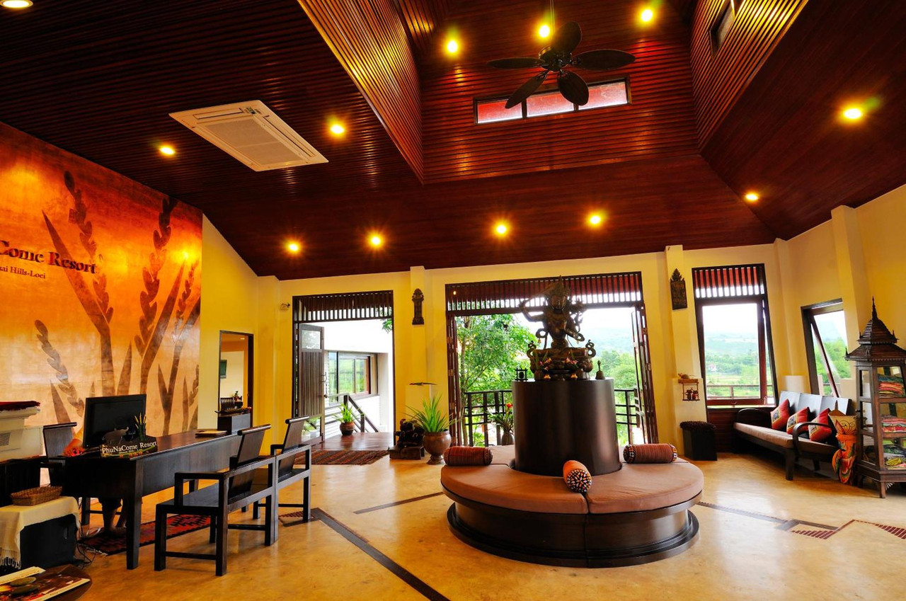Open timber lobby with buffalo-horn lamps looking out over the Dan Sai valley