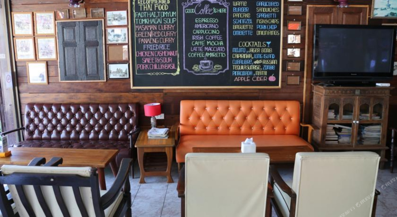 มุมนั่งเล่นและร้านอาหารในตัว ผนังไม้ติดเมนูชอล์กบอร์ดและรูปเมืองลพบุรี