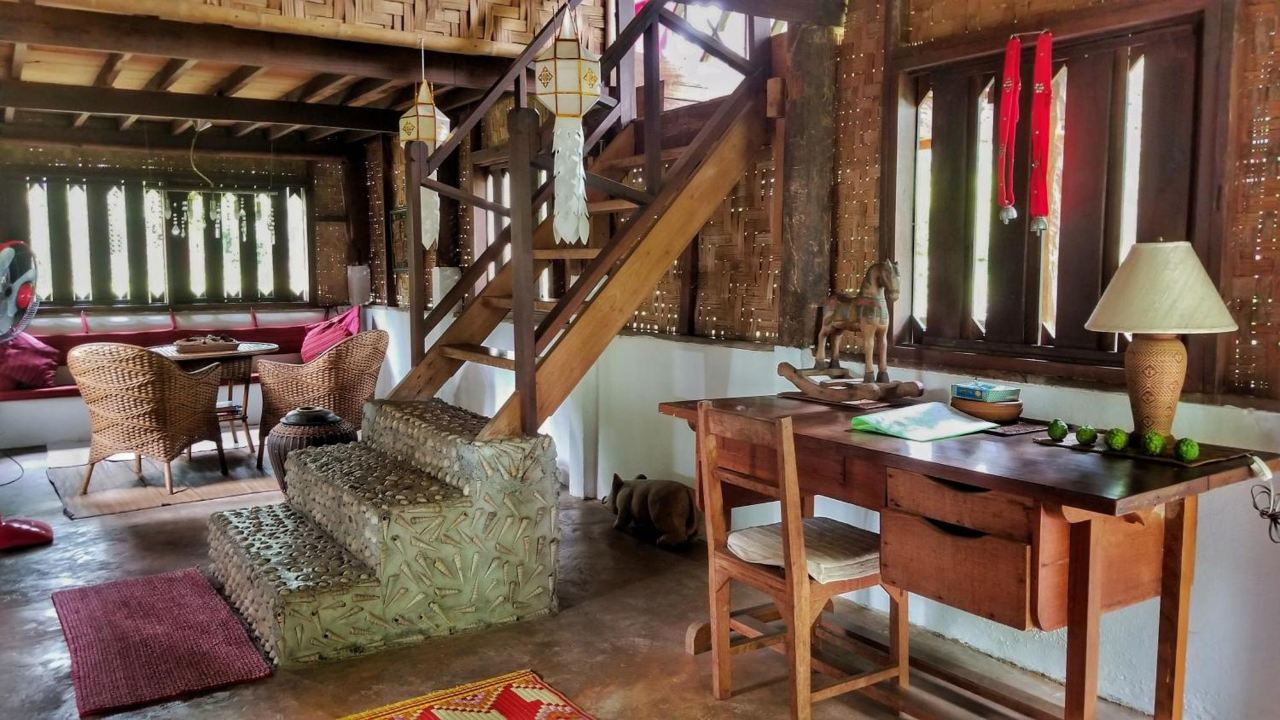 Hut with a loft level, teak writing desk, rattan chairs and local decor