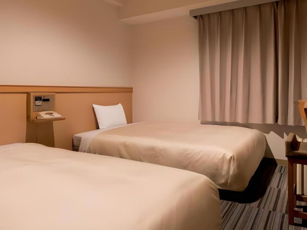ห้อง compact สไตล์ cabin เตียงคู่แยก ผ้าปูขาว แสงอบอุ่น ที่ Premier Hotel Cabin Matsumoto