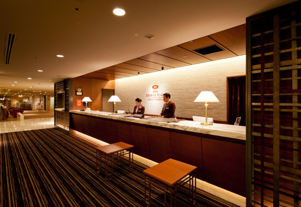 เคาน์เตอร์ต้อนรับและล็อบบี้ของ ANA Crowne Plaza Nagasaki Gloverhill มีพนักงานในชุดยูนิฟอร์มให้บริการ