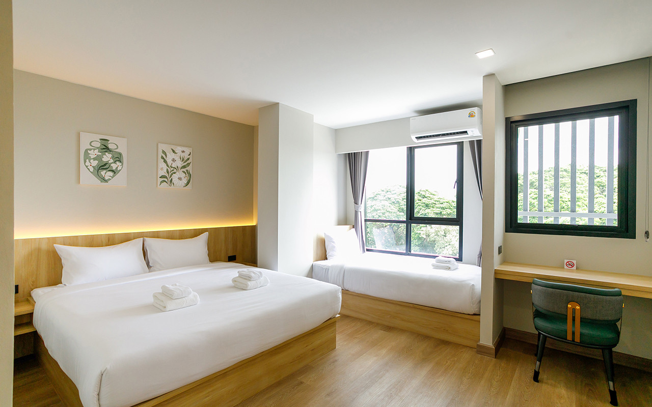 ห้อง Deluxe Triple ของ B2 Nakhon Pathom Premier โทนไม้อ่อน เตียงเดี่ยวริมหน้าต่าง