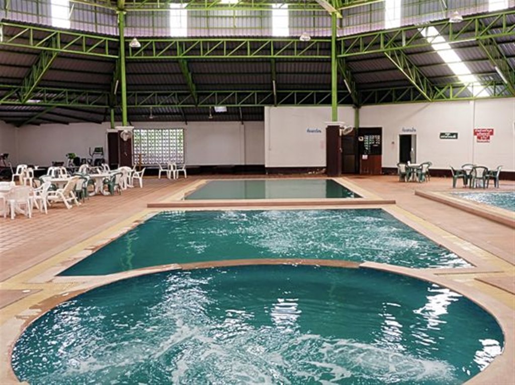 Covered indoor swimming pool with steel-truss roof at Whale Hotel Nakhon Pathom