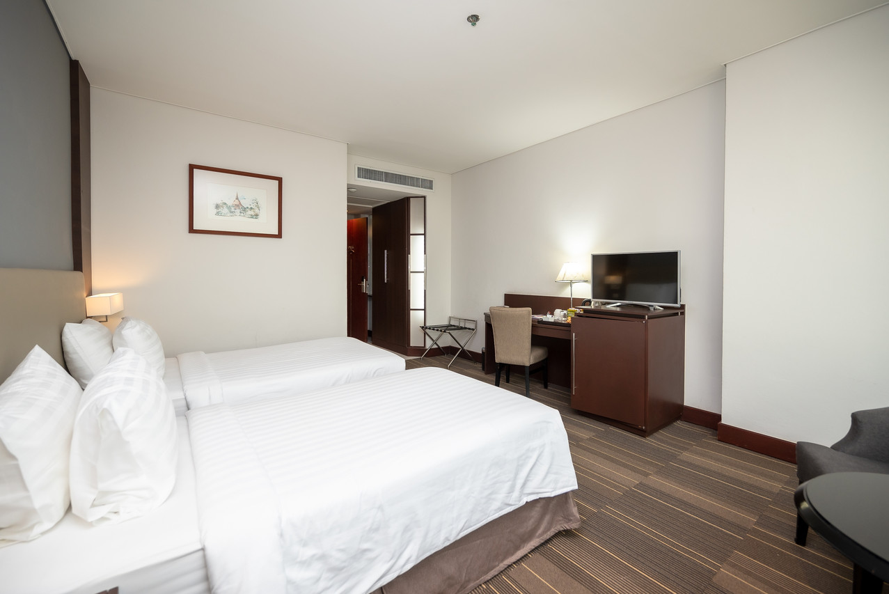 ห้องพัก Fortune Hotel Korat เตียงทวินพร้อมโต๊ะทำงานและทีวี