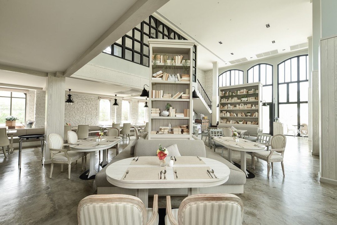 ภายใน The Castle Restaurant เพดานสูง ผนังหิน ชั้นหนังสือสูงจรดเพดาน