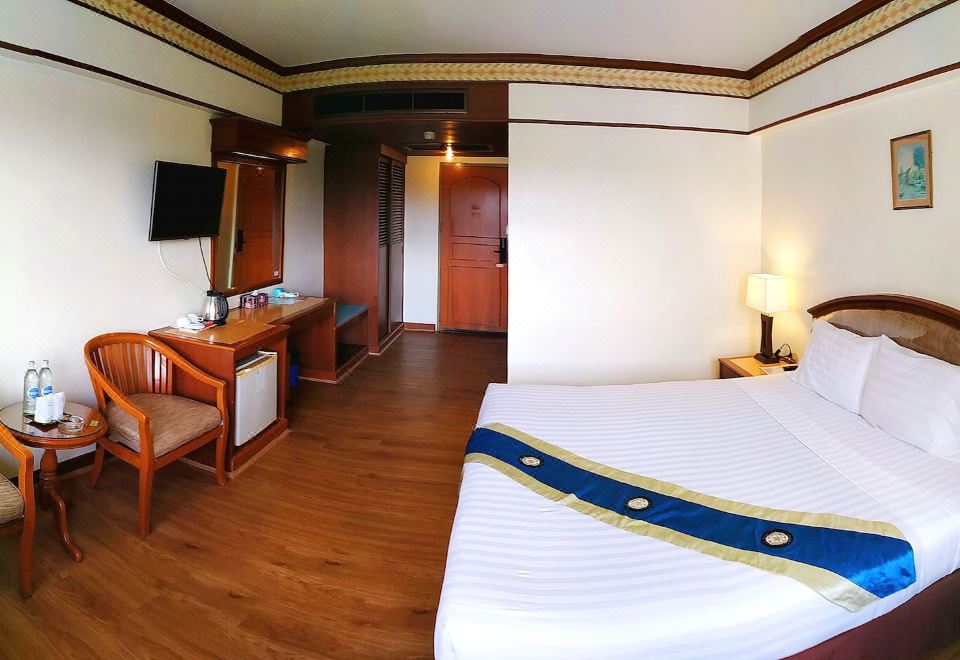 ห้องพักเตียงใหญ่ของ Grand Park Hotel พื้นไม้ โต๊ะทำงาน ทีวีจอแบน