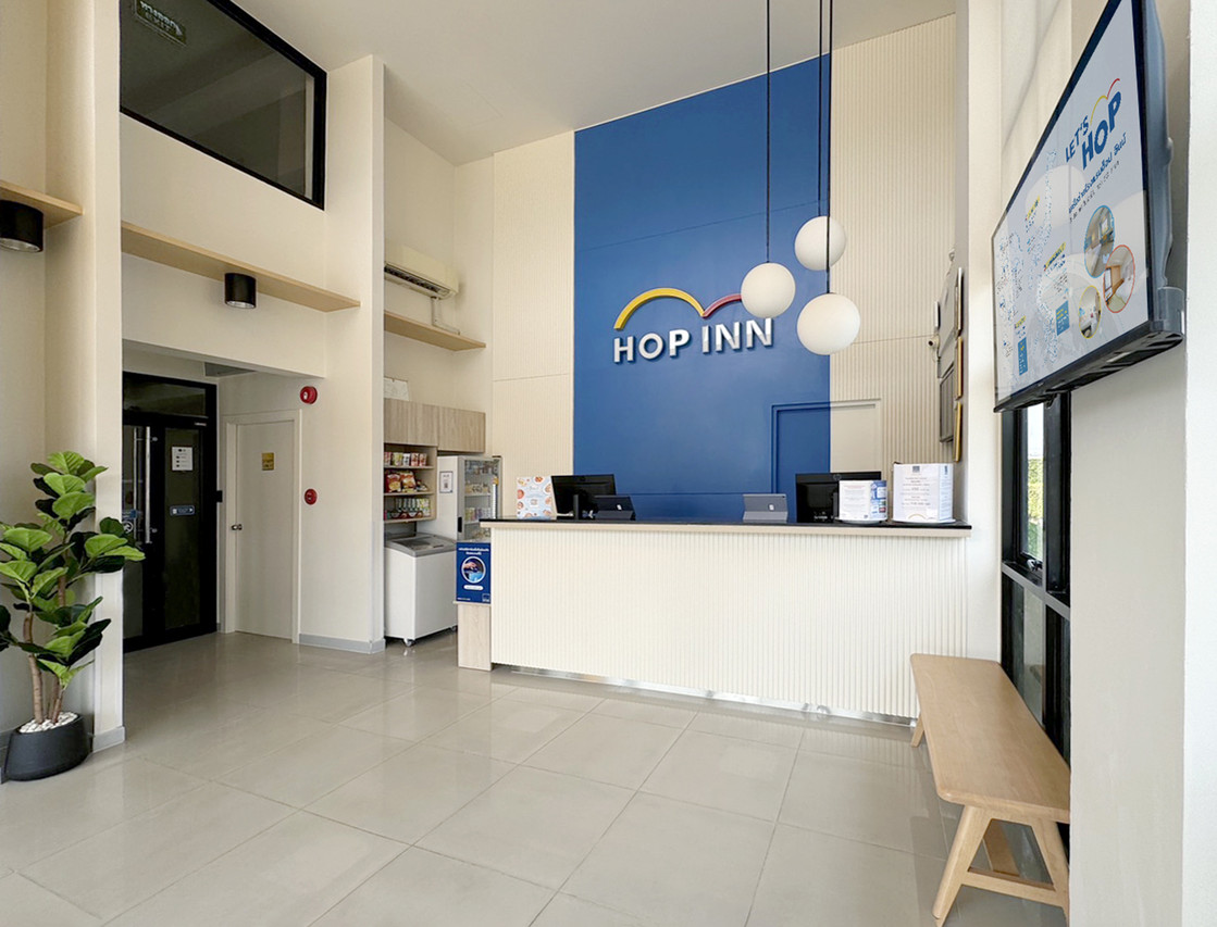 เคาน์เตอร์ต้อนรับและโลโก้ HOP INN ในล็อบบี้ Hop Inn นครศรีธรรมราช